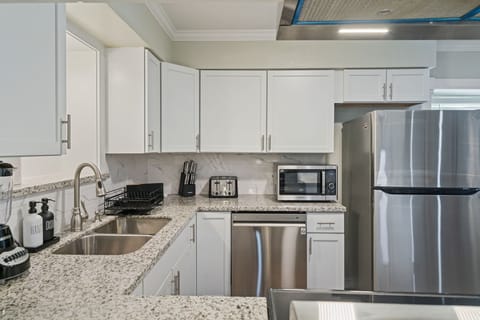 Modern kitchen with microwave, dishwasher, refrigerator/freezer, blender and toaster. Everything needed to cook a meal at home!