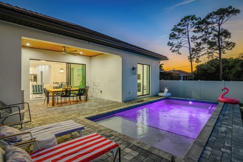 Relax and dine outdoors! Patio with a dining table and propane grill, right next to the pool for perfect poolside meals. | Seaside Sanctuary, Naples, Florida | Voyax Luxury Vacation Rentals