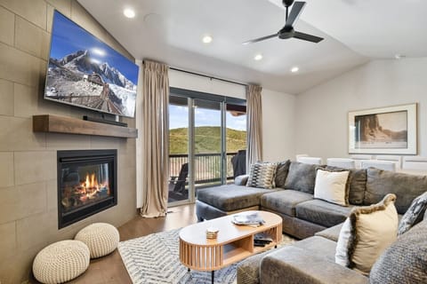 A welcoming living room featuring a cozy sofa, a fireplace, and a large flat-screen TV for ultimate comfort and relaxation.