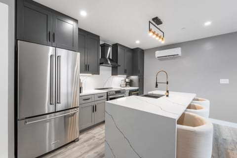 Brand new modern kitchen, featuring stainless steel appliances in a bright and open layout. 