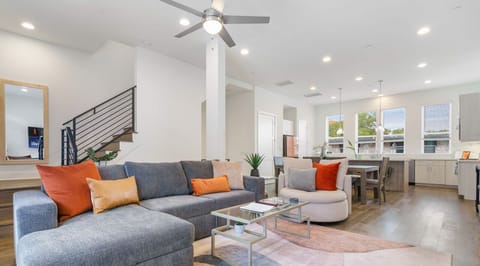 Open and cozy living room with convertible sofa, comfy seating, and balcony