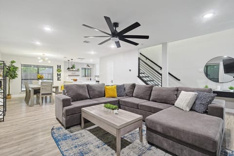 Spacious family room with 70 inch TV, ceiling fan and plenty of seating