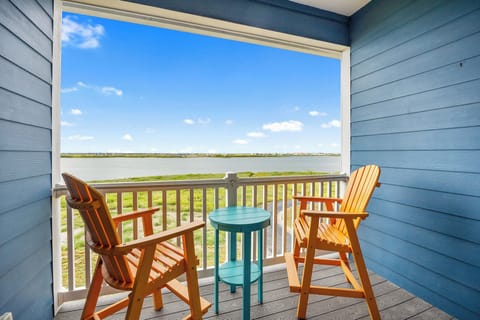 Relax on your private balcony with stunning lake views, where orange Adirondack chairs invite morning coffee moments overlooking peaceful waters.
