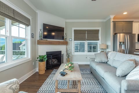 Living room with gas log fireplace, 55" Smart TV for streaming, and access to the covered deck.