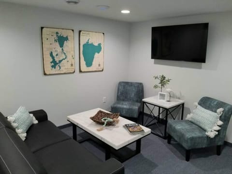 Living room area with smart tv, cable tv and wifi. A couch and 2 chairs.