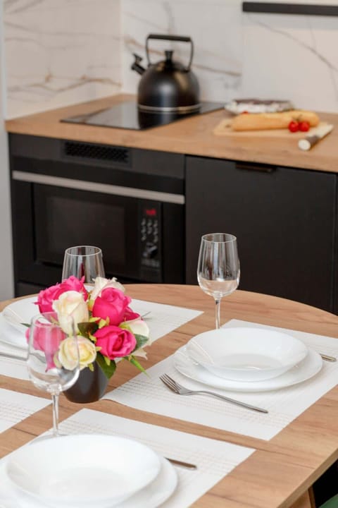 A close-up of a black dining chair with light wooden flooring. Minimalist and modern.