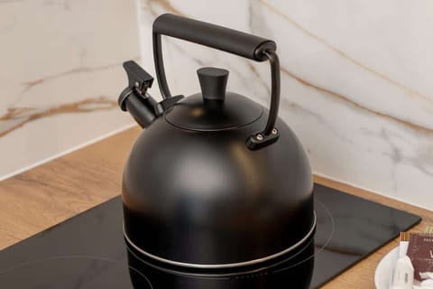 A matte black electric kettle placed on a wooden counter, ready for your next hot drink.