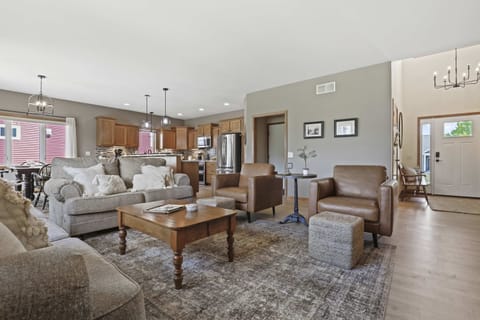 Main level living room with high end furniture, gas fire place, 50" smart TV, and an open living concept.