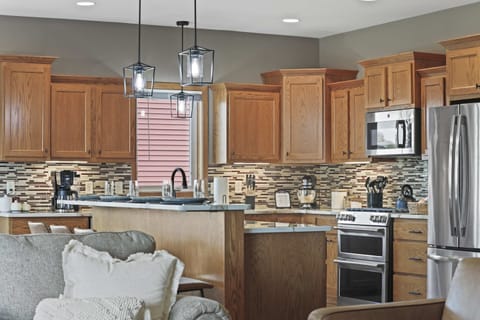 Fully stocked kitchen with barstool seating and a dining table that comfortably seats 6.