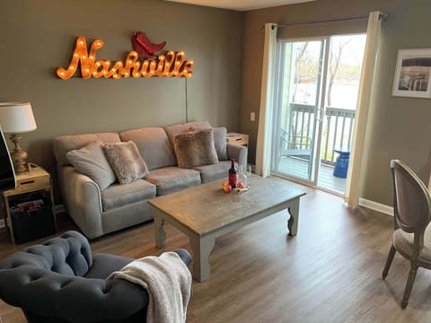Living room with sofa sleeper, Smart TV, and balcony