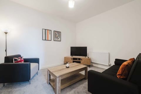 Unwind in the second lounge, featuring a cosy sofa and armchair—perfect for enjoying your favorite shows or relaxing with a good book
