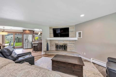 Living room with large-screen TV, seating area for 5 people and a coffee table