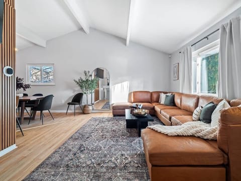 Bright living room w/ large windows, comfy seating & TV for relaxed lounging