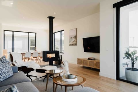 Bright open-plan living space with cozy fireplace, designer furnishings, and plenty of natural light