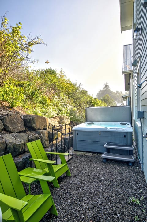 The hot tub and outdoor furniture is located on the back side of the house. 