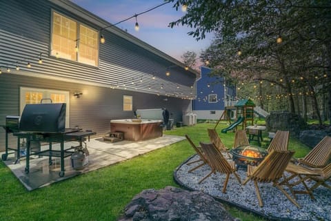 The ultimate backyard setup- featuring  hot tub, barbecue grill, and fire pit