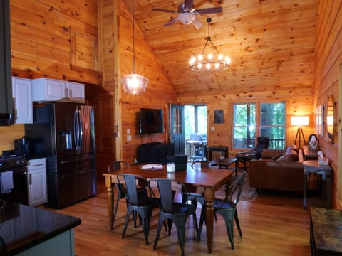 Open layout with vaulted ceilings connects kitchen, dining, and living.