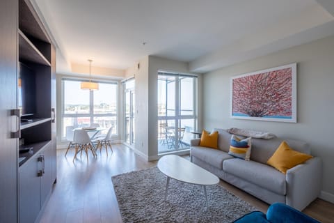 Welcome to your urban oasis! Relax in this bright, open-concept living area with built-in wall cabinetry and direct access to natural light from expansive windows.