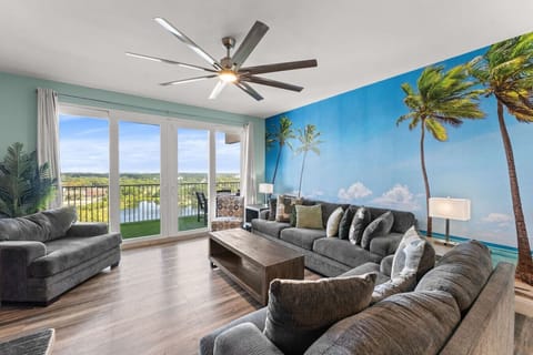 Open-Concept Living Area with Sleeper Sofa, Private Balcony Access, Custom Mural, TV and Lake Views