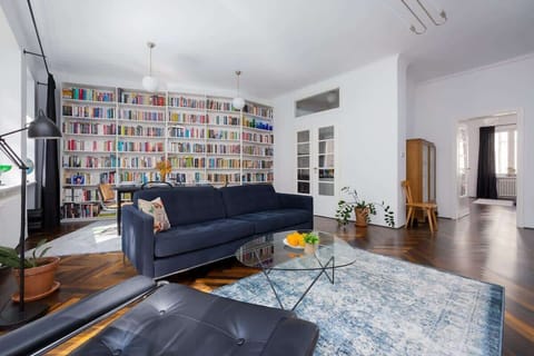  A stylish living room with designer furniture and a wall full of books creates a cozy place to relax.