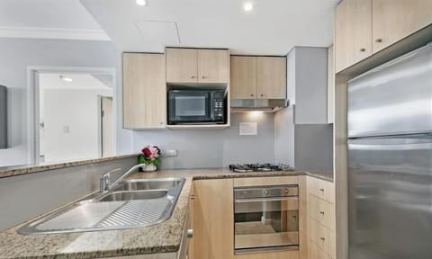 A clean, modern kitchen area equipped with wooden cabinetry