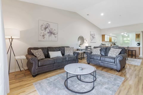 Open living space with sample seating, TV, and balcony access