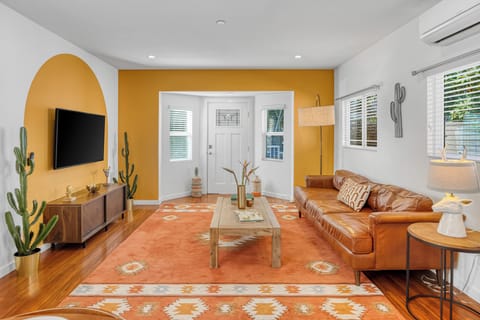 Bright, inviting living room with bold accent walls, cozy leather seating, and stylish desert-inspired décor—perfect for relaxing after a day of adventure.