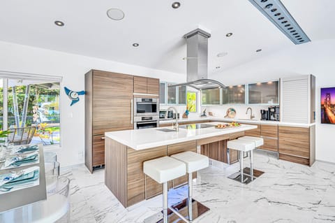 The kitchen opens on the living room and dining area featuring incredible views of the canal and heated pool.