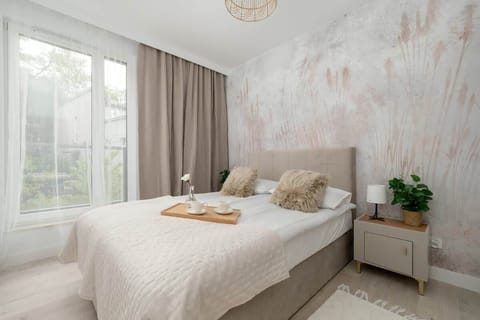 Bright bedroom with elegant wallpaper and a large bed offers comfortable rest in a modern setting.