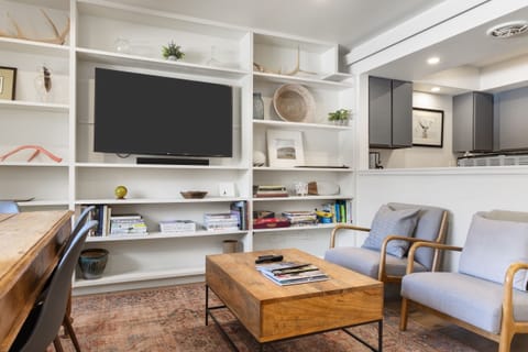 Sink into comfortable chairs while enjoying your favorite shows on the large TV, surrounded by thoughtfully curated shelves and modern design.