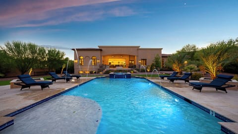 Relax by the sparkling pool with loungers, water features, and desert views.