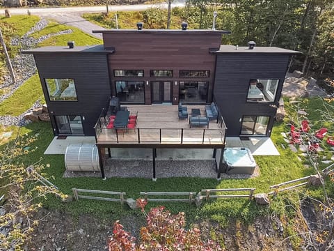 Elevated deck with outdoor dining and hot tub, perfect for relaxing in nature