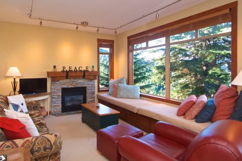 Bright comfortable living room, fireplace, custom window seat and gas fireplace