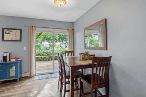 The Main House - Open dining area leading to the deck, offering beautiful lake views and natural light for an idyllic setting.