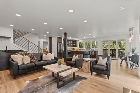 Great room with wet bar, open concept floor plan, large dining table, deck to aspen forest, large kitchen island and more