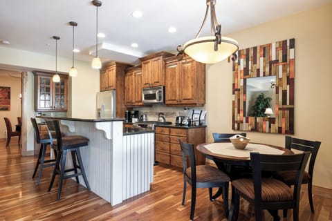 - Enjoy a full kitchen with modern stainless appliances  
- Sit at the bar or gather at the dining table  
- Wood cabinetry and stylish lighting create charm