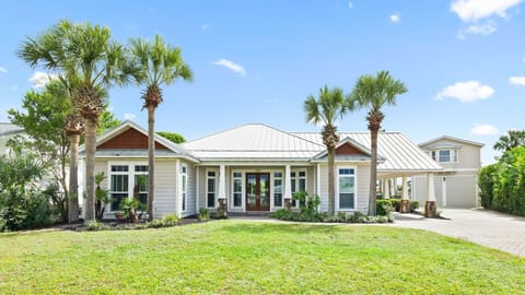 Beautiful coastal home with tropical palm trees and manicured landscaping welcomes guests to their Florida getaway destination.
