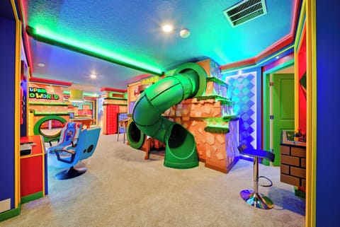 Discover a vibrant playroom designed for creativity and fun, with a playful green slide and colorful decor. The cozy carpet invites relaxation, while dynamic lighting creates an exciting atmosphere for everyone to enjoy.