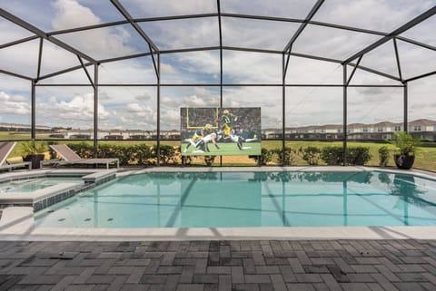Step into a refreshing oasis with a sparkling pool framed by modern pavers and lush greenery. The screened enclosure invites you to enjoy the outdoors while providing a comfortable atmosphere, perfect for relaxing or entertaining.