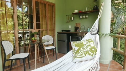 Glass doors deperating the bedroom from the kitchen/terrace area and curtains for privacy