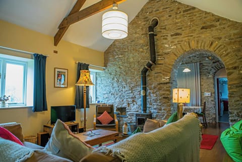 Sitting room with large corner sofa, TV and log burner