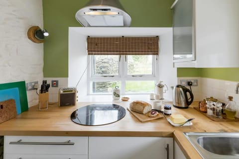 Sink, cabinet with bread and butter, kettle, and tea making items