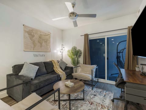 Cozy living area w/ sofa, accent chairs & sliding doors opening to a private balcony