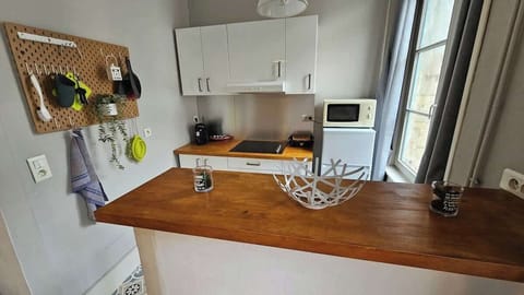 Cuisine ouverte sur le salon, équipée avec micro-ondes, plaques de cuisson, bouilloire, machine à café et réfrigérateur avec congélateur.
Coin repas rapide pour deux personnes.