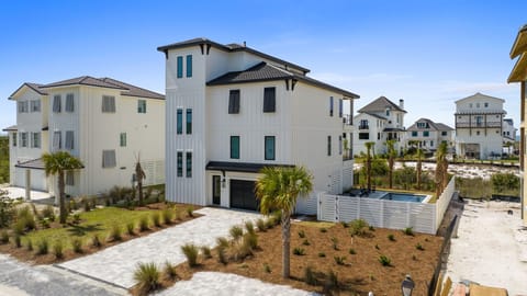 Modern coastal vacation home featuring multiple stories, private pool, and tropical landscaping in a beach neighborhood setting.