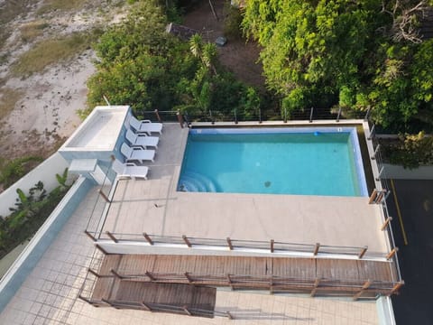 Rooftop pool w/ lounge chairs & surrounding greenery—perfect for a refreshing dip or relaxing under the sun