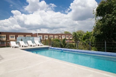 Resort-style outdoor pool w/ lounge chairs & open sky views for sunny afternoon swims