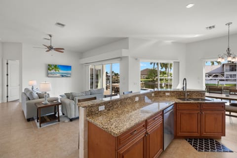 Kitchen with 6 stools looking at living room and canal