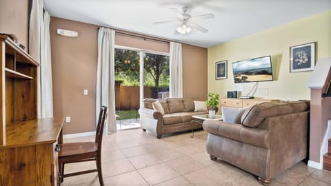 Cozy living room with leather sofas and natural light from sliding glass doors.