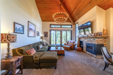 Large living area with gas burning fireplace, TV w/ smart features, and private deck access.